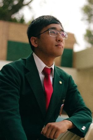 services-1 Stylish young man in a green suit with red tie and eyeglasses outdoors.